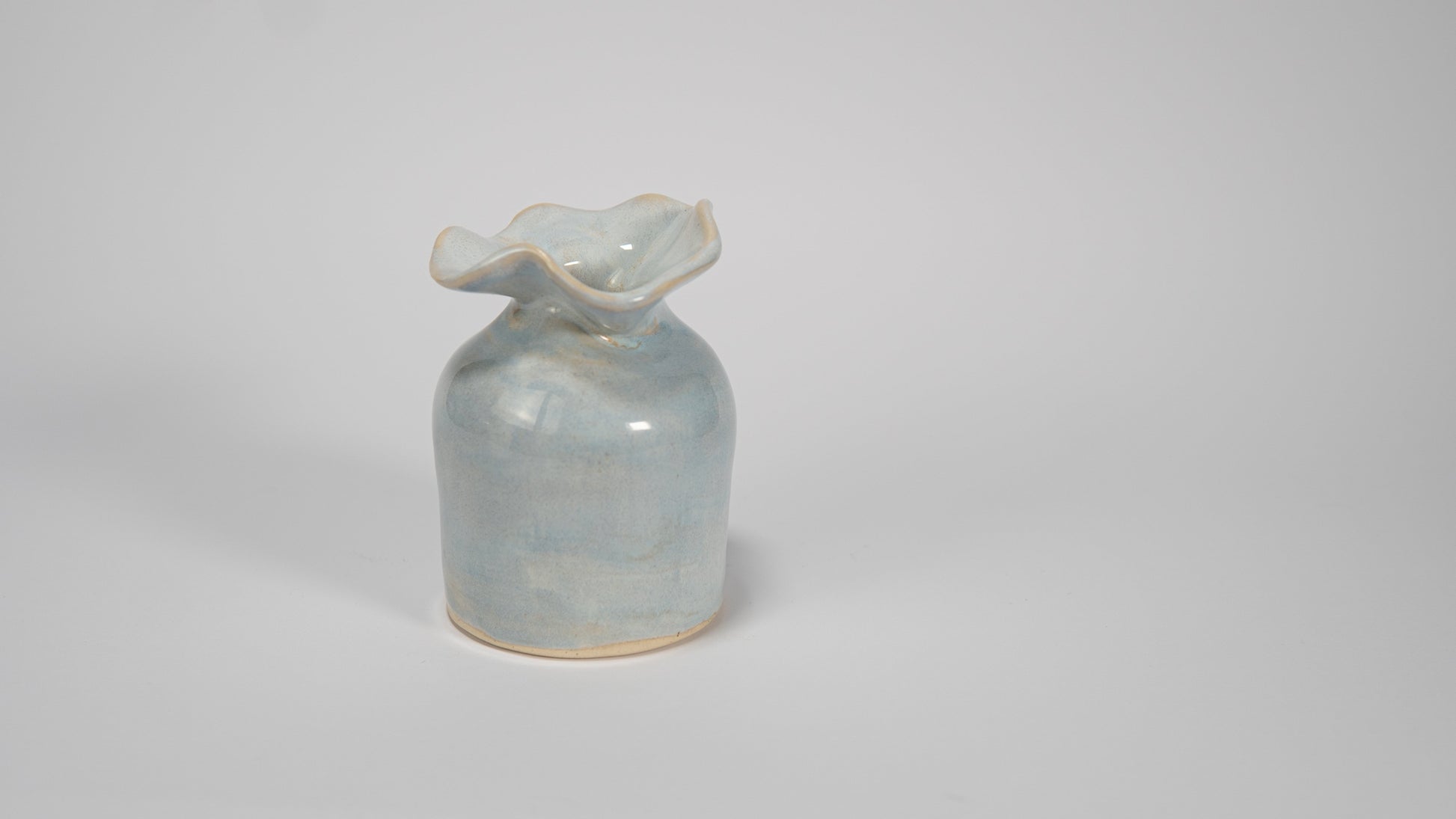 Small ceramic vase with a textured surface on a plain background